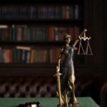 Lady Justice and gavel on a table in a classic law library setting.